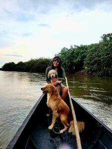 a woman and a dog in a boat on the water at Hato San Pablo in Guayabal
