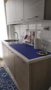 a kitchen with a sink and a blue counter top at Appartamento Nautes in San Benedetto del Tronto