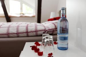 Una botella de agua y dos vasos en una mesa. en Pension Altes Burghotel, en Neustadt-Glewe