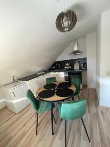 uma cozinha com uma mesa e cadeiras verdes num quarto em Ferienwohnung Marie em Rüdesheim am Rhein