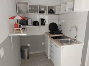 a small white kitchen with a sink and a counter at Studios Ciao Bella city centre with free parking in Šibenik