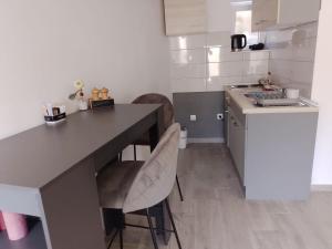 een keuken met een tafel en stoelen en een wastafel bij Apartments Ciao Bella city centre with free parking in Šibenik