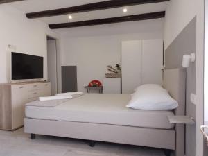 een witte slaapkamer met 2 bedden en een flatscreen-tv bij Apartments Ciao Bella city centre with free parking in Šibenik