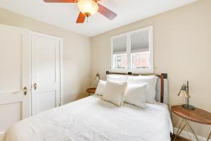 a bedroom with a white bed with a ceiling fan at Modern Alexandria Townhome about 2 Mi to Old Town! in Alexandria