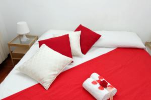 um quarto com 2 camas com almofadas vermelhas e brancas em Sanctuary Home 32 em Roma
