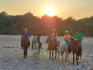 a group of people riding horses on the beach at Hato San Pablo in Guayabal