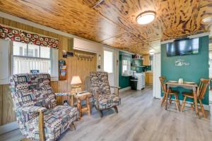 a living room with two chairs and a table at Waterfront Paradise Lake Cottage with Pvt Dock! in Carp Lake