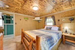 a bedroom with a bed and a wooden ceiling at Waterfront Paradise Lake Cottage with Pvt Dock! in Carp Lake