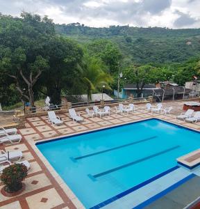 a swimming pool with chairs and a table and a mountain at MIRADOR VILLA MERCEDES in Melgar