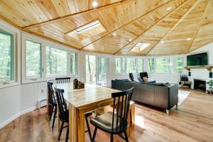 a living room with a wooden ceiling and a table and chairs at Pocono Pines Penthouse with Private Deck! in Pocono Pines