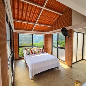 a bedroom with a white bed in a room with windows at MIRADOR VILLA MERCEDES in Melgar
