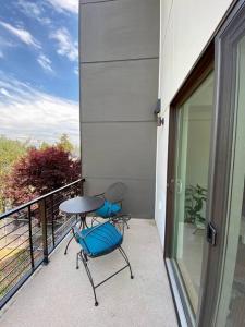 a patio with two chairs and a table on a balcony at Modern two story townhouse near light rail in Seattle