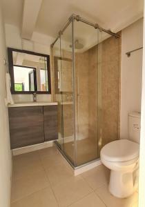 a bathroom with a toilet and a glass shower at MIRADOR VILLA MERCEDES in Melgar