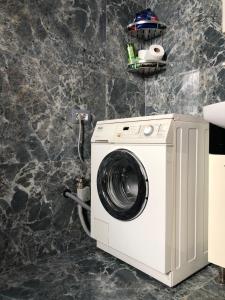 uma máquina de lavar roupa na casa de banho com uma parede de pedra em Vila Murati em Tirana