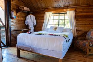 ein Schlafzimmer mit einem Bett in einem Blockhaus in der Unterkunft Villa Mexicana Creel Mountain Lodge in Creel