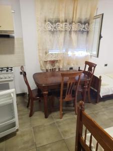 a kitchen with a wooden table and chairs and a window at Altiku Apartments in Golem