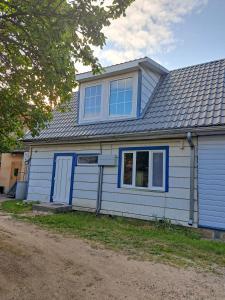a white house with blue doors and windows at Sadama Stay in Haapsalu