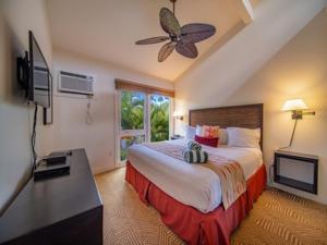 a bedroom with a large bed and a television at Aina Nalu Lahaina in Lahaina