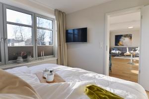 Un dormitorio con una gran cama blanca con una mesa. en Helle Deel, en Fehmarn