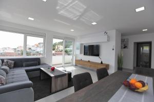 ein Wohnzimmer mit einem Sofa und einem Tisch in der Unterkunft Apartmani Ive in Trogir