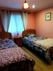 1 dormitorio con 2 camas y ventana en Cabaña en Recinto con piscina y tinaja, en Chillán