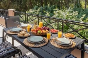 a picnic table with food on a balcony at Villa Apanemo in Potamós