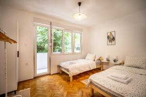 1 dormitorio con 2 camas y ventana en Cozy apartment, 10 minutes walking distance from the Old Town, en Kotor