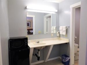 a bathroom with a sink and a mirror at Windsor Motel in Groton