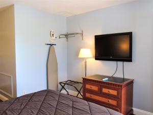 a bedroom with a bed and a flat screen tv at Windsor Motel in Groton