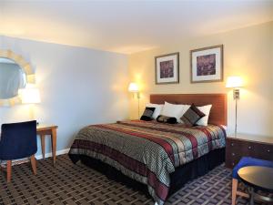 ein Hotelzimmer mit einem Bett und einem Schreibtisch in der Unterkunft Windsor Motel in Groton