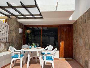 d'une terrasse avec une table et des chaises blanches. dans l'établissement Guayana 23 beach apartment, à Mogán
