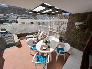 Un patio con una mesa y sillas en un balcón. en Guayana 23 beach apartment, en Mogán