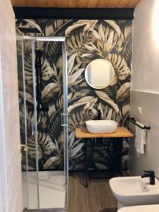 ein Bad mit einem Waschbecken und einem Spiegel in der Unterkunft Vecchio Loft con Jacuzzi in Syrakus