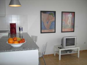 kuchnia z misą owoców i telewizorem w obiekcie Casa Oscar - Apartment w mieście Roque