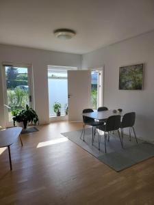 a living room with a dining room table and chairs at Cozy and bright apartment in Viby