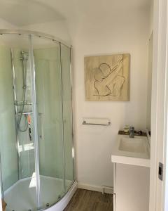 a bathroom with a glass shower and a sink at Cozy and bright apartment in Viby