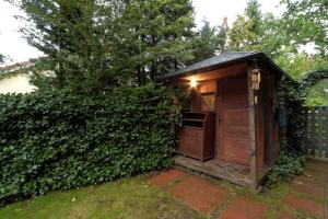 un gabinetto esterno in legno in un giardino vicino ad una siepe di Two-level apartament + garden. Dwupoziomowe mieszkanie + ogród a Gdynia