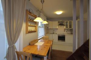 una cucina con tavolo in legno e una sala da pranzo di Two-level apartament + garden. Dwupoziomowe mieszkanie + ogród a Gdynia