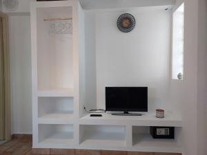 Camera bianca con TV su una parete bianca di Small houses anna&sofos a Kardámaina