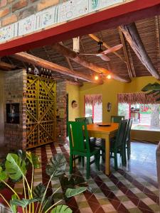 a dining room with a table and green chairs at Hato San Pablo in Guayabal