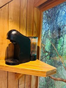 a coffee maker sitting on a wooden shelf next to a window at Tamarindo Pura Selva Eco Tree House in Guatemala