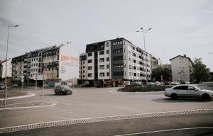 a parking lot with cars in a parking lot with buildings at Apartman Pelagić in Brčko