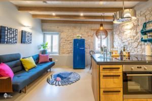 salon z niebieską kanapą i kuchnią w obiekcie Casa Amando Eco Boutique House w Rovinj