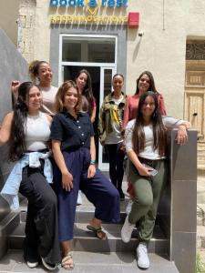 a group of women sitting on the steps of a building at Bookarest Hostel Malta in St. Julianʼs