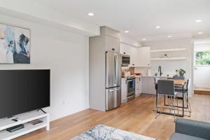 a kitchen and living room with a tv and a table at Modern two story townhouse near light rail in Seattle