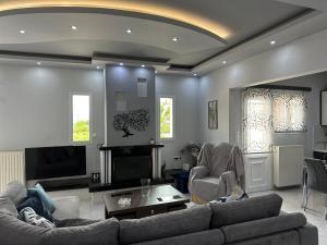 sala de estar con sofá, sillas y TV en Luxury apartment, en Amarinto