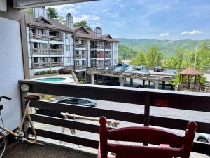 uma cadeira vermelha sentada na varanda de um hotel em Relaxing Mountain Condo in Gatlinburg with City view ! em Gatlinburg