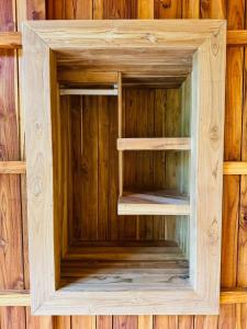 a wooden book shelf in a wooden wall at Tamarindo Pura Selva Eco Tree House in Guatemala
