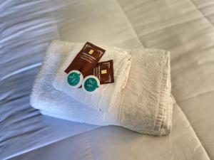 a white towel with chocolate and two stickers on a bed at Hotel Chagual in La Serena