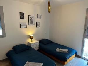Pokój z dwoma łóżkami i lampką na stole w obiekcie Solesmes 72 w mieście Solesmes